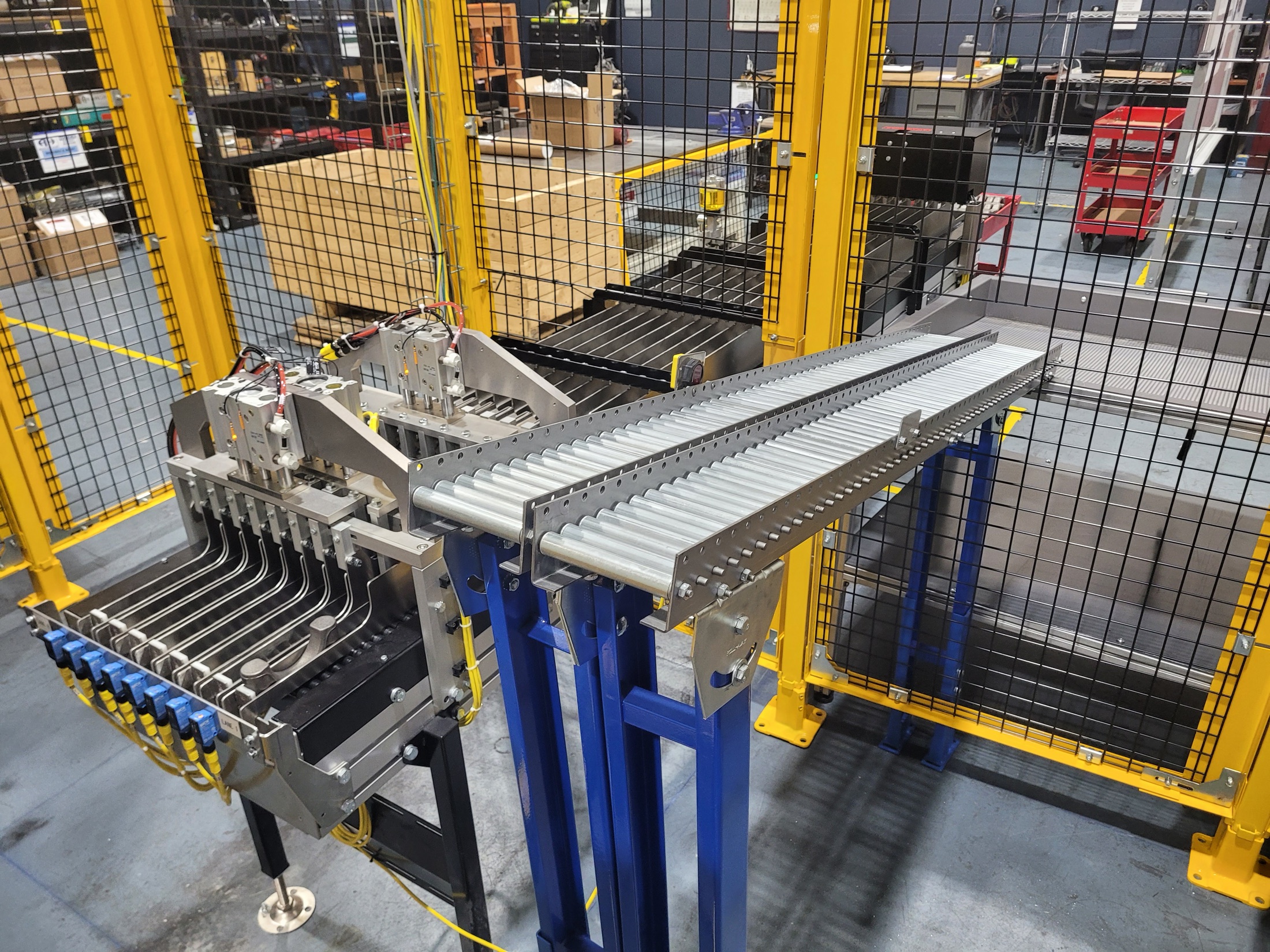 Conveyor to fixture handoff area for automated cell flow.
